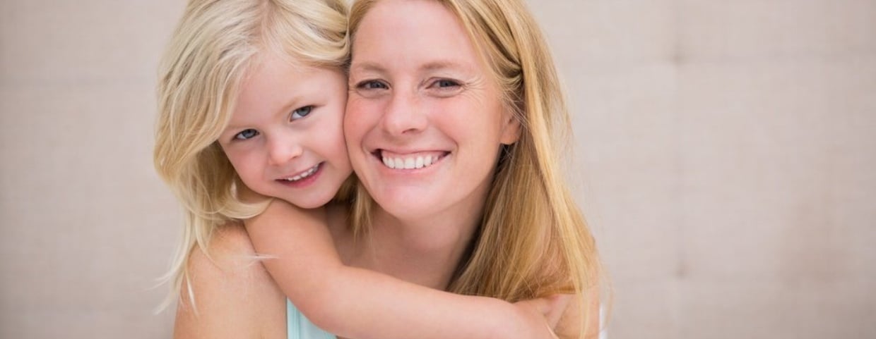 Cute little girl and mother on bed at home in the bedroom