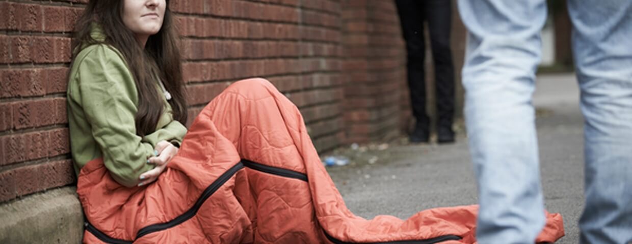 Girl in sleeping bag on street
