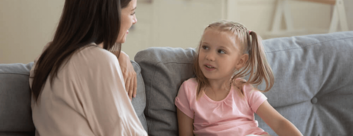 mother and daughter sitting on couch talking, parent child conversation